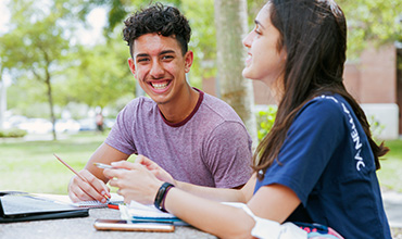 Young man and lady working together on FIT campus